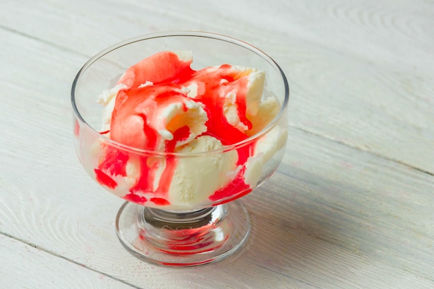 Delicioso tazón de helado de vainilla con cobertura de fresa