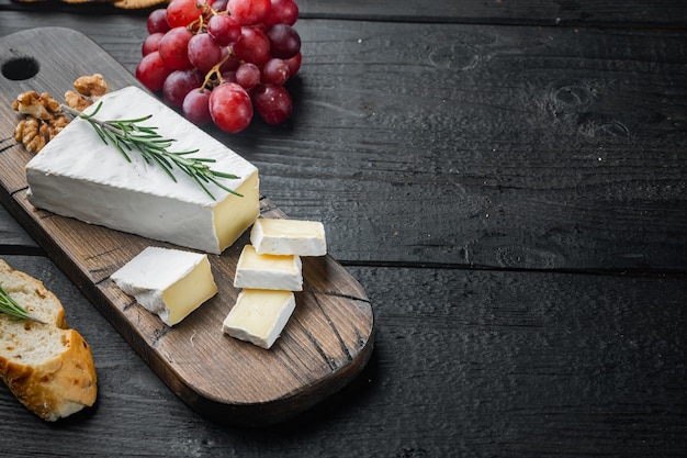 Delicioso trozo de queso brie, sobre mesa de madera negra con espacio para copiar texto