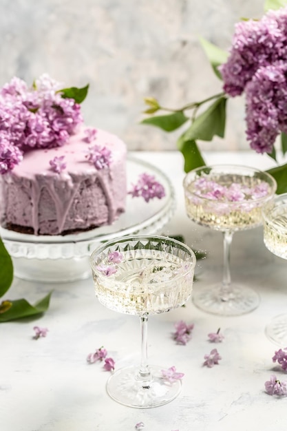 Delicioso vinho de champanhe prosecco com buquê de bolo de mousse de baga de lilases roxos florescendo fundo de cartão postal da culinária francesa