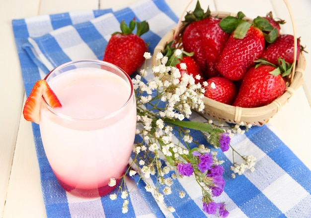 Delicioso yogur de fresa en vidrio sobre mesa de madera closeup