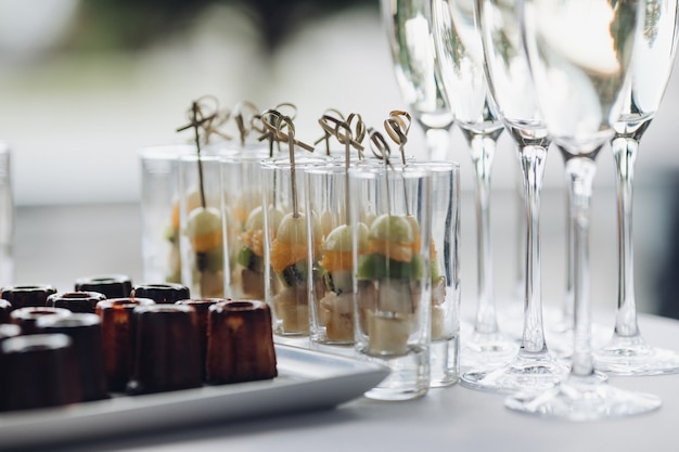 Deliciosos aperitivos de frutas saludables y copas de vino.