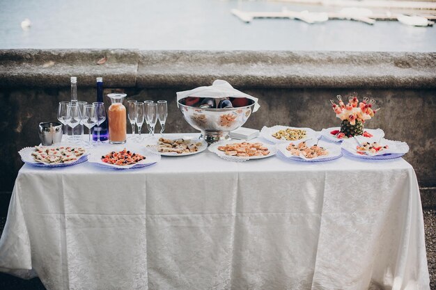 Deliciosos aperitivos italianos na mesa na recepção do casamento ao ar livre Caviar frutos do mar canapés taças de champanhe e vinho na mesa no casamento ou festa de natal Catering de luxo ao ar livre