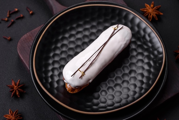 Deliciosos beneficios frescos o eclair con chocolate en un plato de cerámica negra