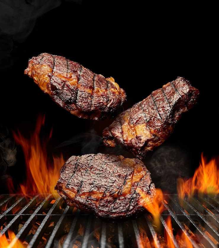 Foto deliciosos bifes grelhados de porco ou de boi estão caindo