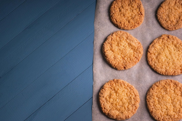 Deliciosos biscoitos caseiros em papel manteiga sobre fundo azul de madeira