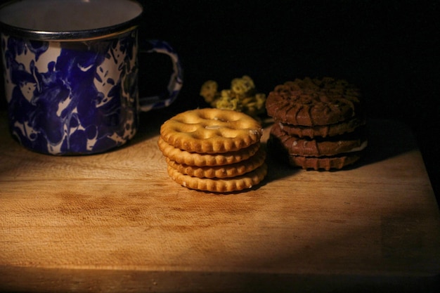 Deliciosos biscoitos de chocolate doce em uma mesa de madeira com pouca luz