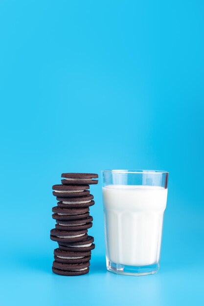 Deliciosos biscoitos de chocolate preto doce com recheio de leite isolado em fundo azul