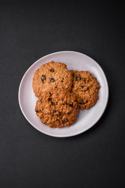 Deliciosos biscoitos de passas de aveia cozidos em um fundo escuro de concreto