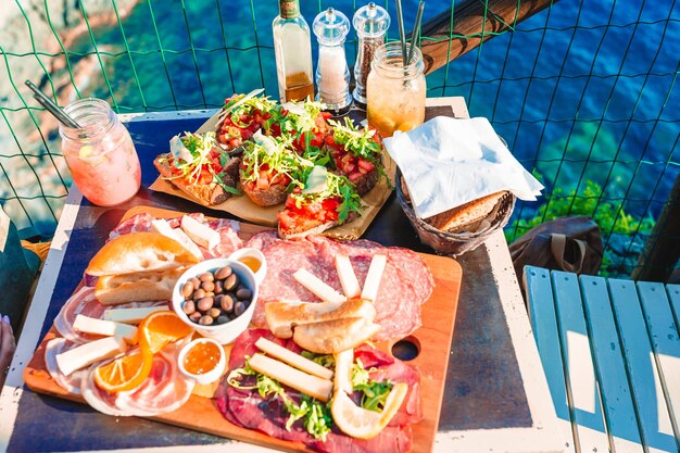 Deliciosos bocadillos italianos Bruschettes frescos quesos y carne en el tablero en el café con vista en Manarola