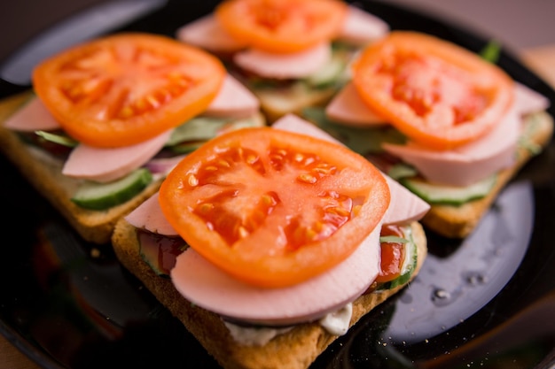 Deliciosos bocadillos con tomate y salchicha en un plato