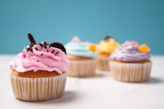 Deliciosos bolinhos caseiros com Creme Colorido e cobertura com Doces e Biscoitos de Chocolate.