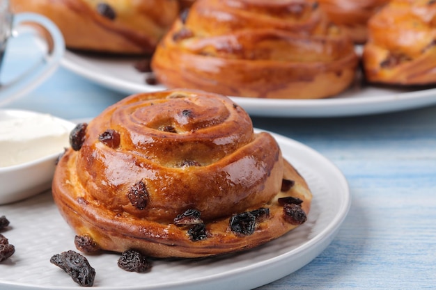 Deliciosos bollos con pasas y mantequilla en una mesa de madera azul claro. panadería fresca. desayuno. pan de molde.