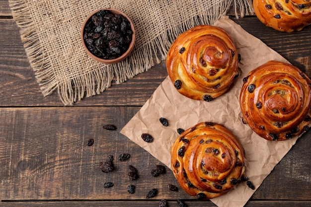 Deliciosos bollos con pasas en una mesa de madera marrón. panadería fresca. desayuno. pan de molde. vista superior