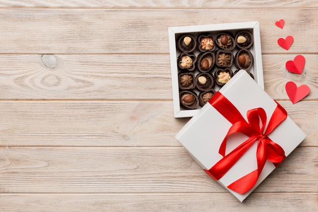 Deliciosos bombons de chocolate em caixa vermelha para o Dia dos Namorados Caixa de chocolates em forma de coração vista superior com espaço para cópia