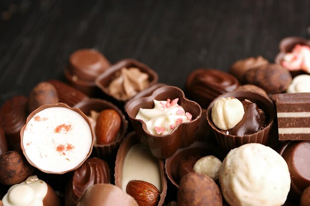 Deliciosos bombons de chocolate em fundo de madeira close-up