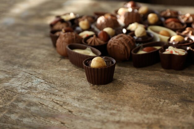 Deliciosos bombons de chocolate em fundo de madeira, close-up