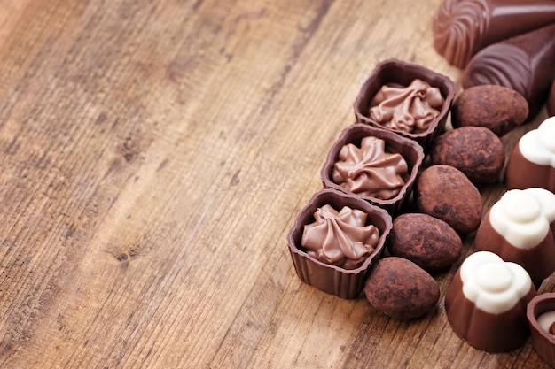 Deliciosos bombons de chocolate em fundo de madeira