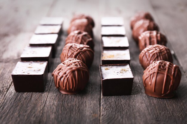 Deliciosos bombons de chocolate em fundo de madeira