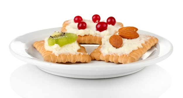 Deliciosos canapés con queso, kiwi y arándano, almendra, en placa de color, en blanco