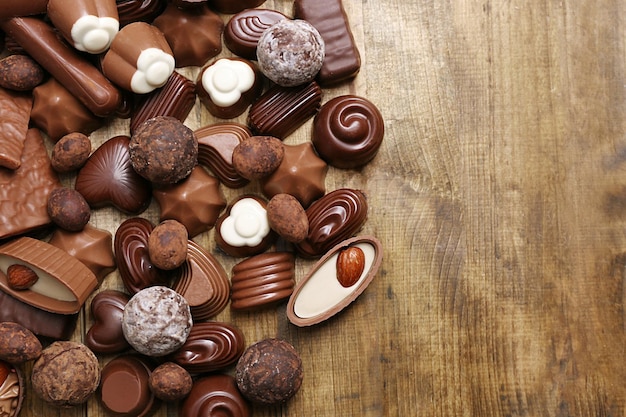 Deliciosos caramelos de chocolate sobre fondo de madera