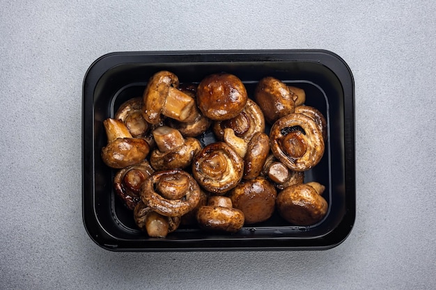 Deliciosos champiñones en una caja negra Entrega