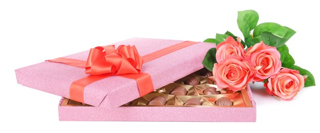 Deliciosos chocolates en caja con flores aislado en blanco