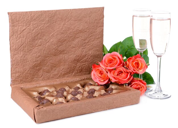 Deliciosos chocolates en caja con flores aislado en blanco