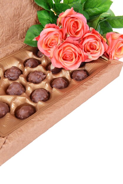 Foto deliciosos chocolates en caja con primer plano de flores