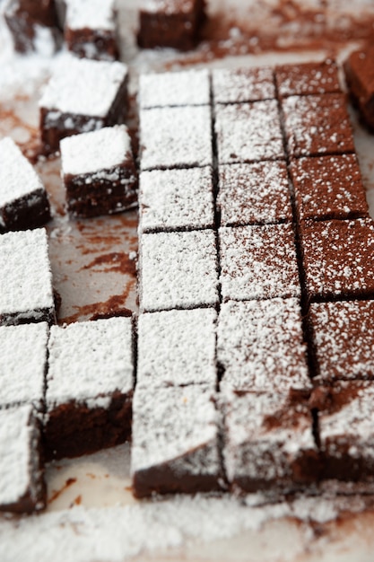 Deliciosos chocolates crus caseiros cortados em formas quadradas polvilhados com açúcar de confeiteiro