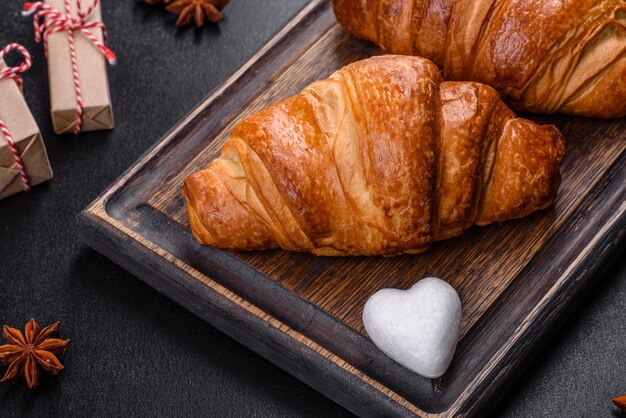 Deliciosos croissants frescos y crujientes sobre un fondo de hormigón oscuro. sabroso desayuno