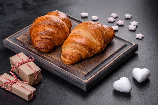 Deliciosos croissants frescos y crujientes sobre un fondo de hormigón oscuro. sabroso desayuno