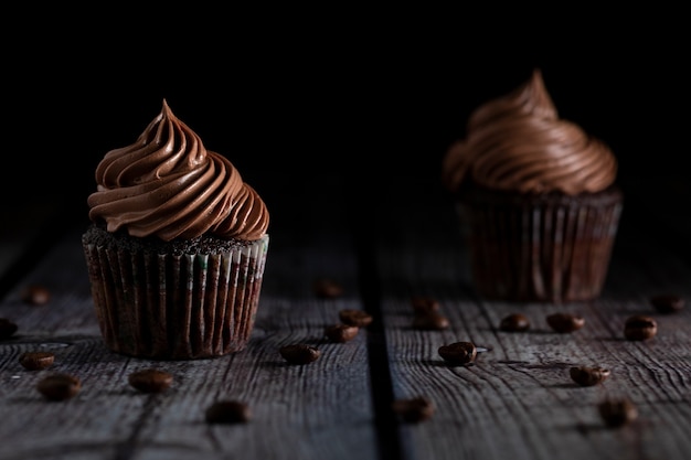 Deliciosos cupcakes de chocolate y café bajo luz suave sobre mesa de madera