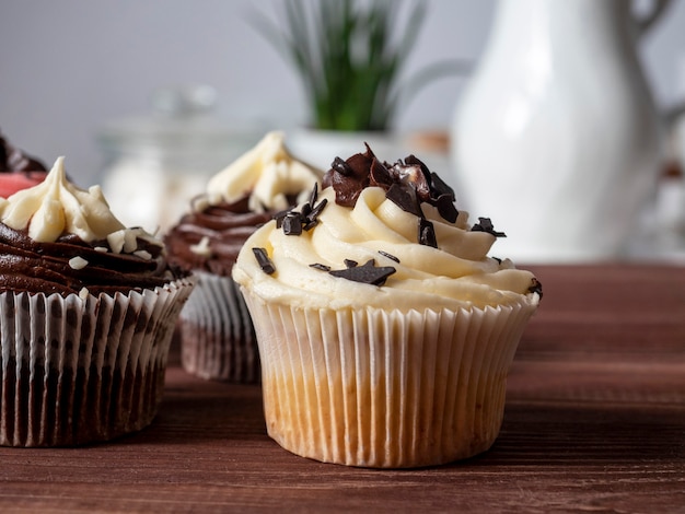 Deliciosos cupcakes de chocolate hechos a mano dulces en una mesa de madera. Productos de repostería fina. Vista frontal