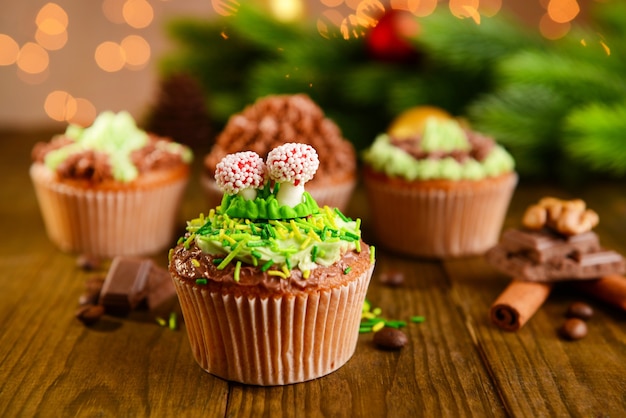 Deliciosos cupcakes con crema de mantequilla, sobre mesa de madera, brillante