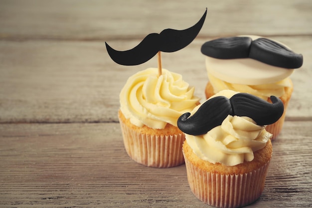 Deliciosos cupcakes criativos na mesa de madeira