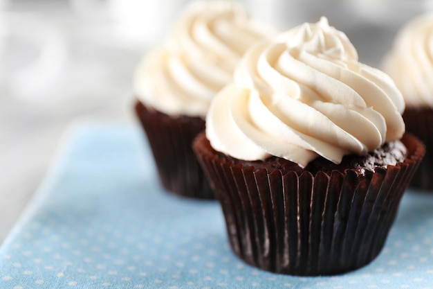 Deliciosos cupcakes de chocolate com creme na mesa servida close-up