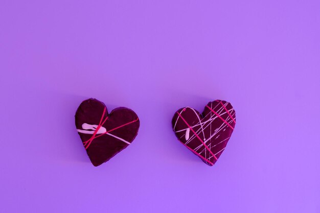 Deliciosos cupcakes en forma de corazón, pasteles para el Día de San Valentín con fondo morado. comida creativa