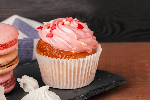 Deliciosos cupcakes de frambuesa y caramelo sobre fondo oscuro