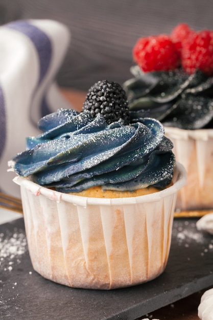 Deliciosos cupcakes en una mesa de madera oscura.