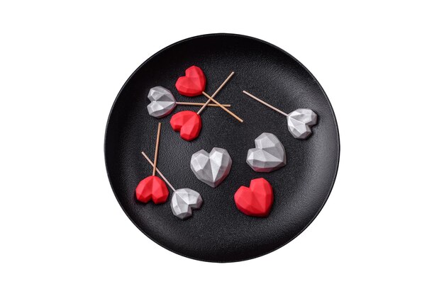 Deliciosos doces de chocolate em forma de coração em um fundo de concreto escuro Celebração do Dia dos Namorados
