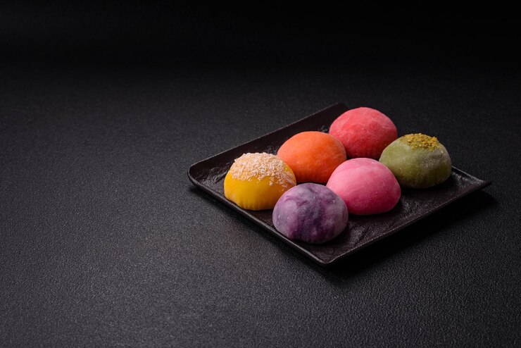 Foto deliciosos doces mochi asiáticos coloridos com casca de massa de arroz e recheio de frutas