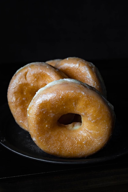 Deliciosos donuts de azúcar sobre un fondo oscuro