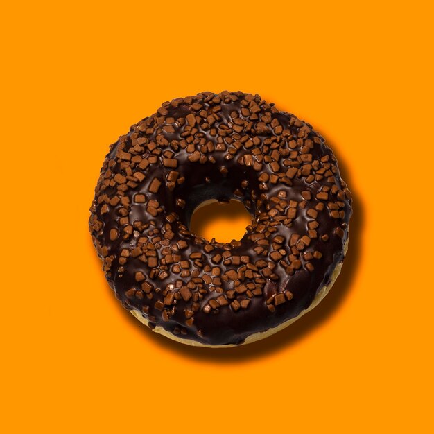 Deliciosos donuts con chocolate negro aislado sobre fondo naranja 3