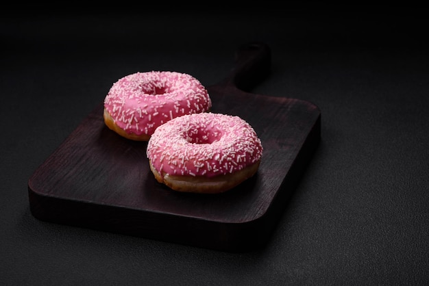 Deliciosos donuts doces frescos em esmalte rosa com recheio de morango