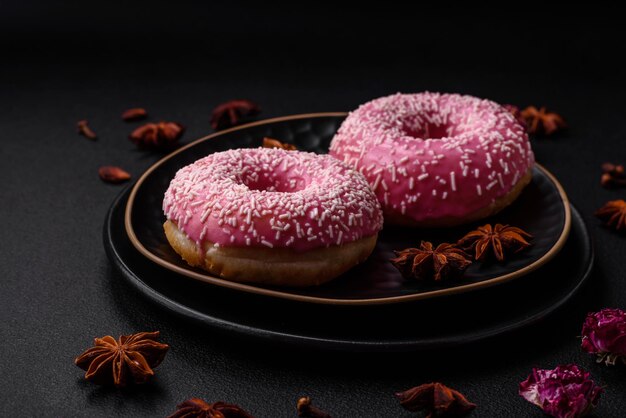 Deliciosos donuts dulces frescos en glaseado rosa con relleno de fresa