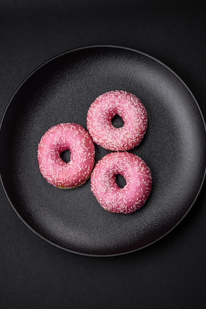 Deliciosos donuts dulces frescos en glaseado rosa con relleno de fresa