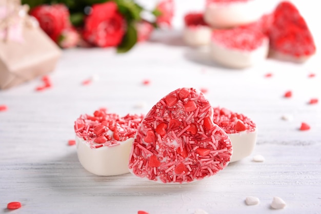 Deliciosos dulces de chocolate en forma de corazón en el primer plano de la mesa