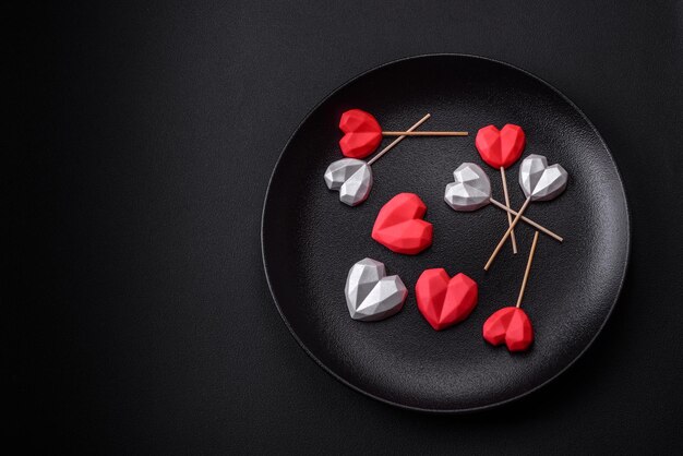 Deliciosos dulces de chocolate en forma de corazón sobre un fondo de hormigón oscuro