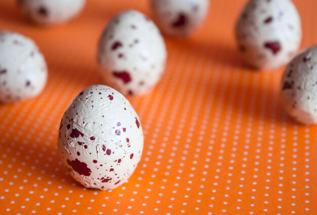 Deliciosos dulces de huevos de Pascua de chocolate sobre fondo naranja lunares. Concepto de vacaciones.