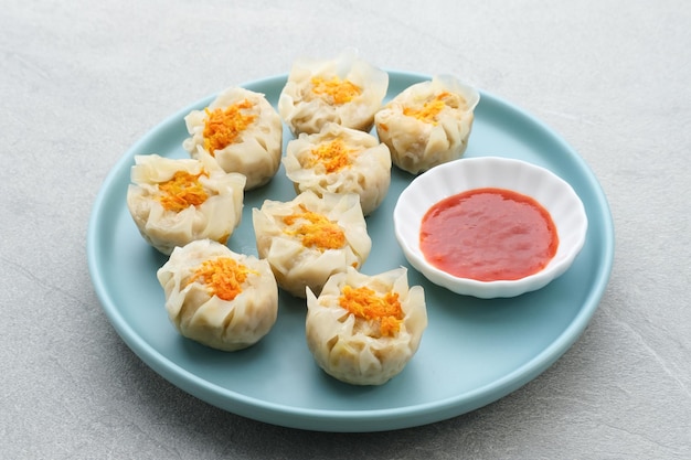 Deliciosos dumplings chinos caseros de Dim Sum servidos en un plato con salsa y palillos